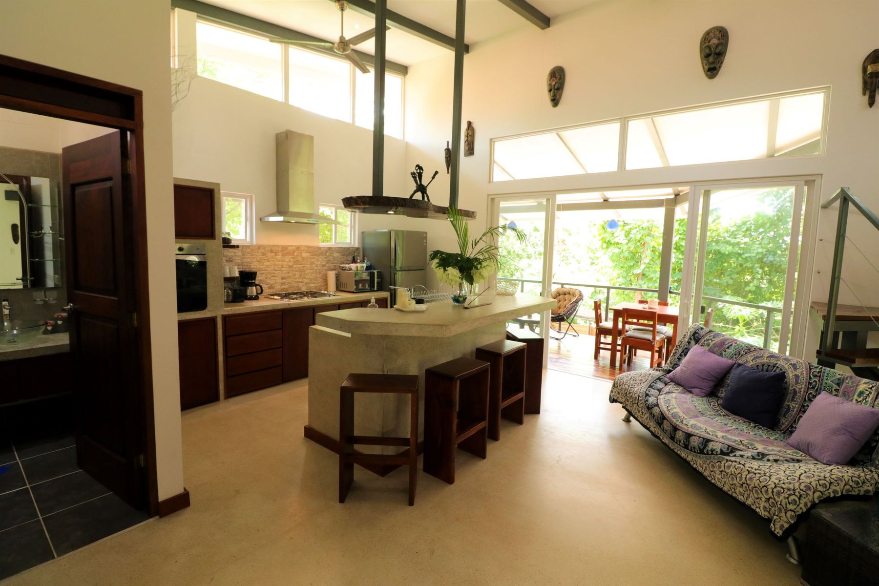 Open living and kitchen under a vaulted steel roof